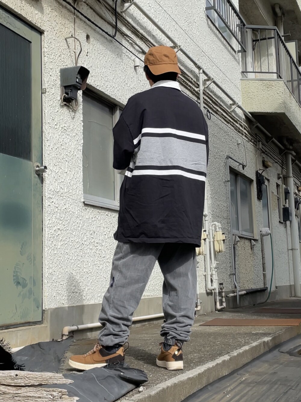 ブラウン系のスニーカー、グレー系のスウェットパンツ、ブラック系のTシャツ/カットソーを着用したメンズの春コーディネートの2枚目の写真