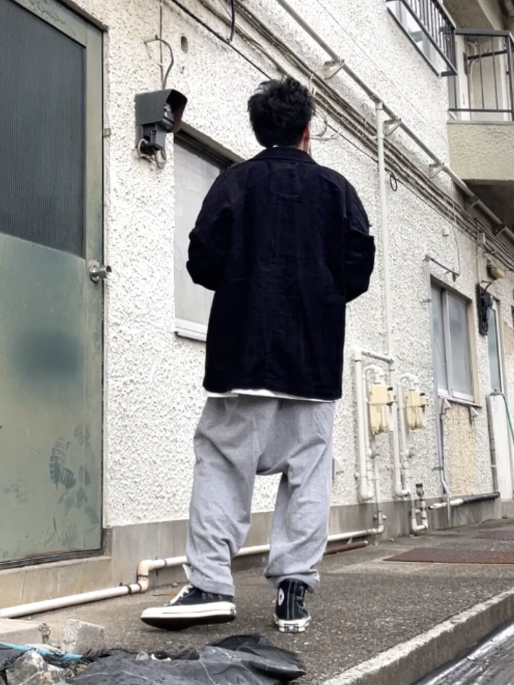 ブラック系のスニーカー、グレー系のその他パンツ、ブルー系のジャケット/アウターを着用したメンズの秋コーディネートの3枚目の写真