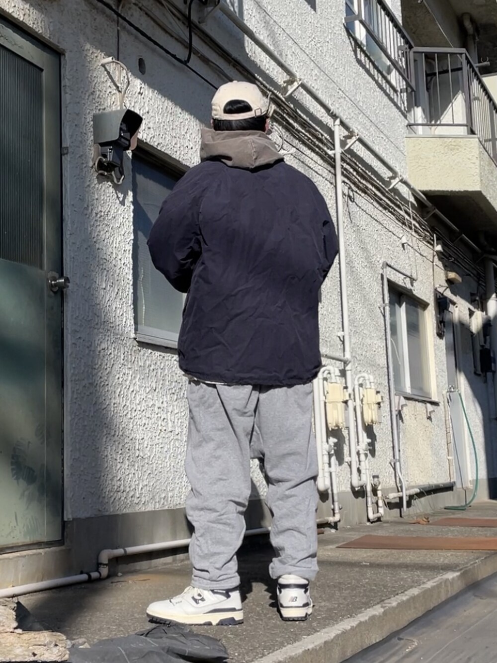 ホワイト系のスニーカー、グレー系のその他パンツ、ブラウン系のパーカーを着用したメンズの冬コーディネートの2枚目の写真