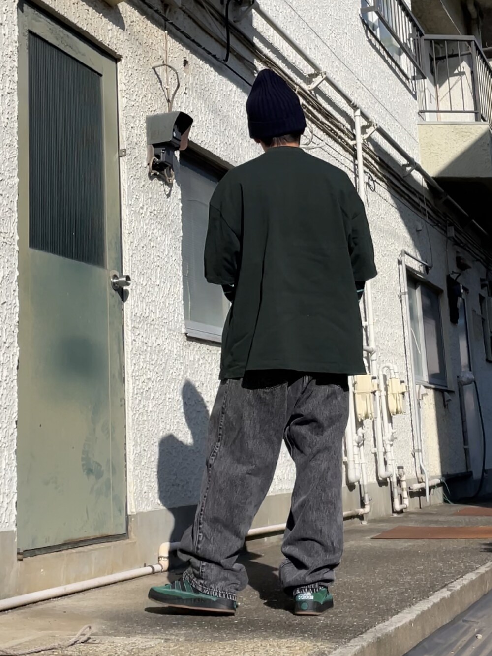 グリーン系のスニーカー、ブラック系のデニムパンツ、グリーン系のTシャツ/カットソーを着用したメンズの秋コーディネートの2枚目の写真