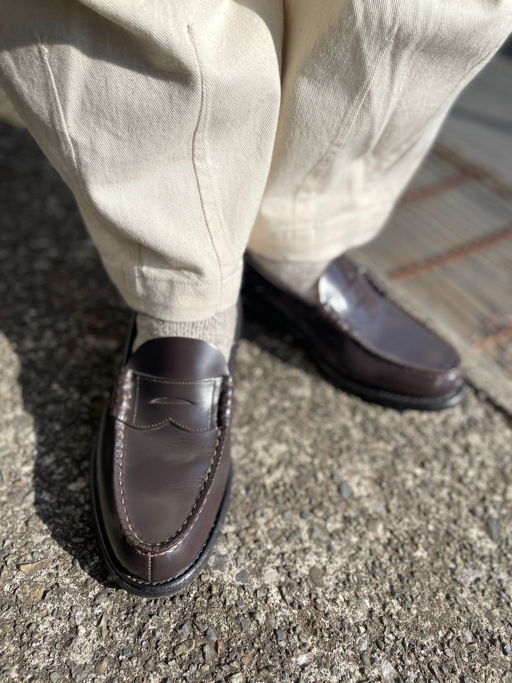 ブルー系のデニムジャケット、ブラウン系のローファー、ホワイト系のデニムパンツを着用したメンズの冬コーディネートの3枚目の写真