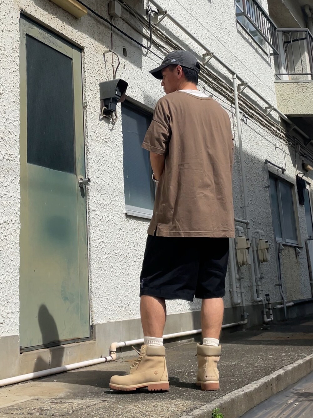 ベージュ系のブーツ、ブラック系のその他パンツ、ベージュ系のTシャツ/カットソーを着用したメンズの夏コーディネートの2枚目の写真