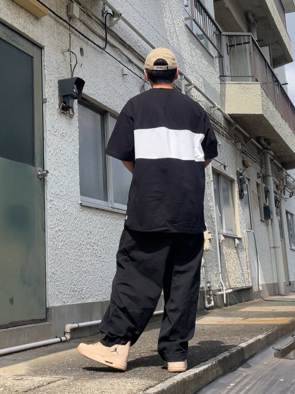 ベージュ系のスニーカー、ブラック系のパンツ、ブラック系のTシャツ/カットソーを着用したメンズの秋コーディネートの2枚目の写真