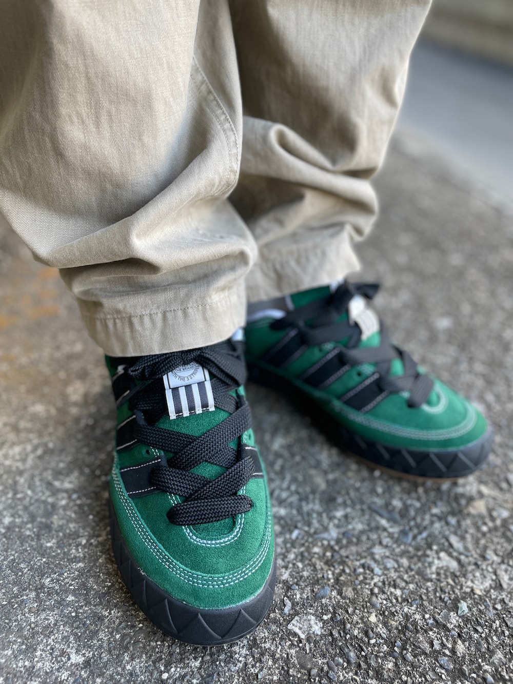 グリーン系のスニーカー、ベージュ系のチノパンツ、グリーン系のTシャツ/カットソーを着用したメンズの秋コーディネートの3枚目の写真