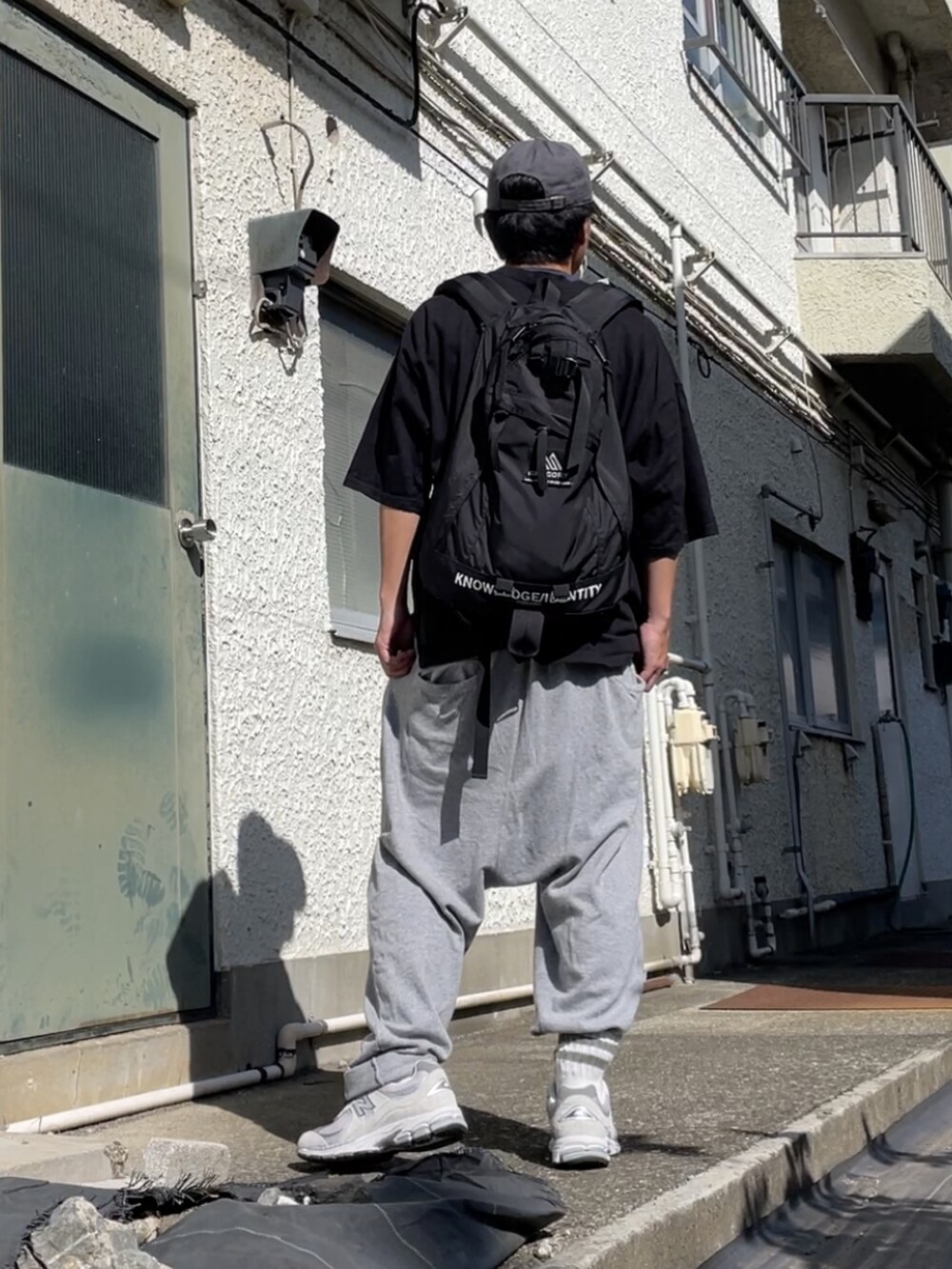 グレー系のスニーカー、グレー系のその他パンツ、ブラック系のTシャツ/カットソーを着用したメンズの秋コーディネートの2枚目の写真