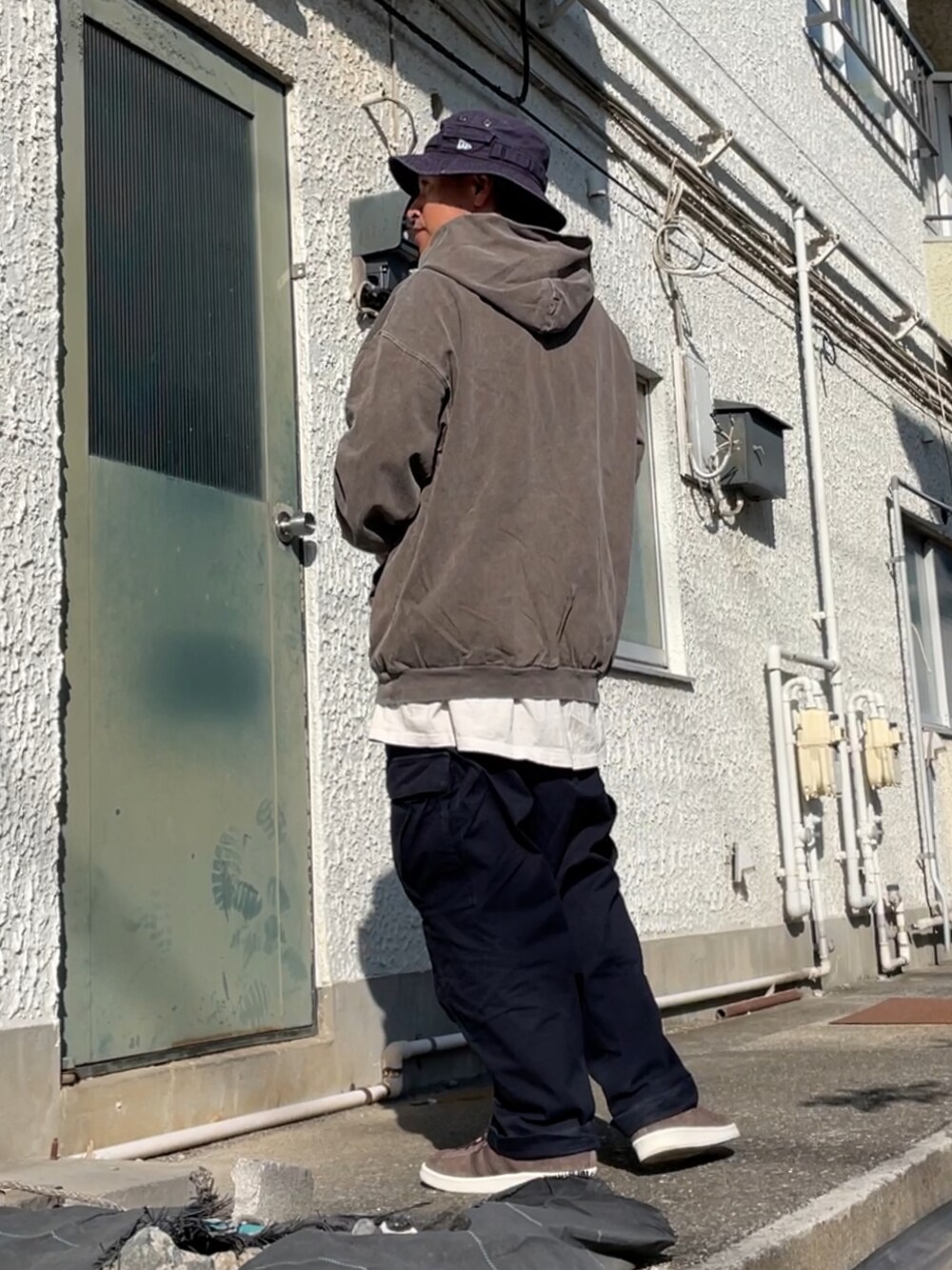 ブラウン系のスニーカー、ブルー系のカーゴパンツ、ブラウン系のパーカーを着用したメンズの秋コーディネートの2枚目の写真