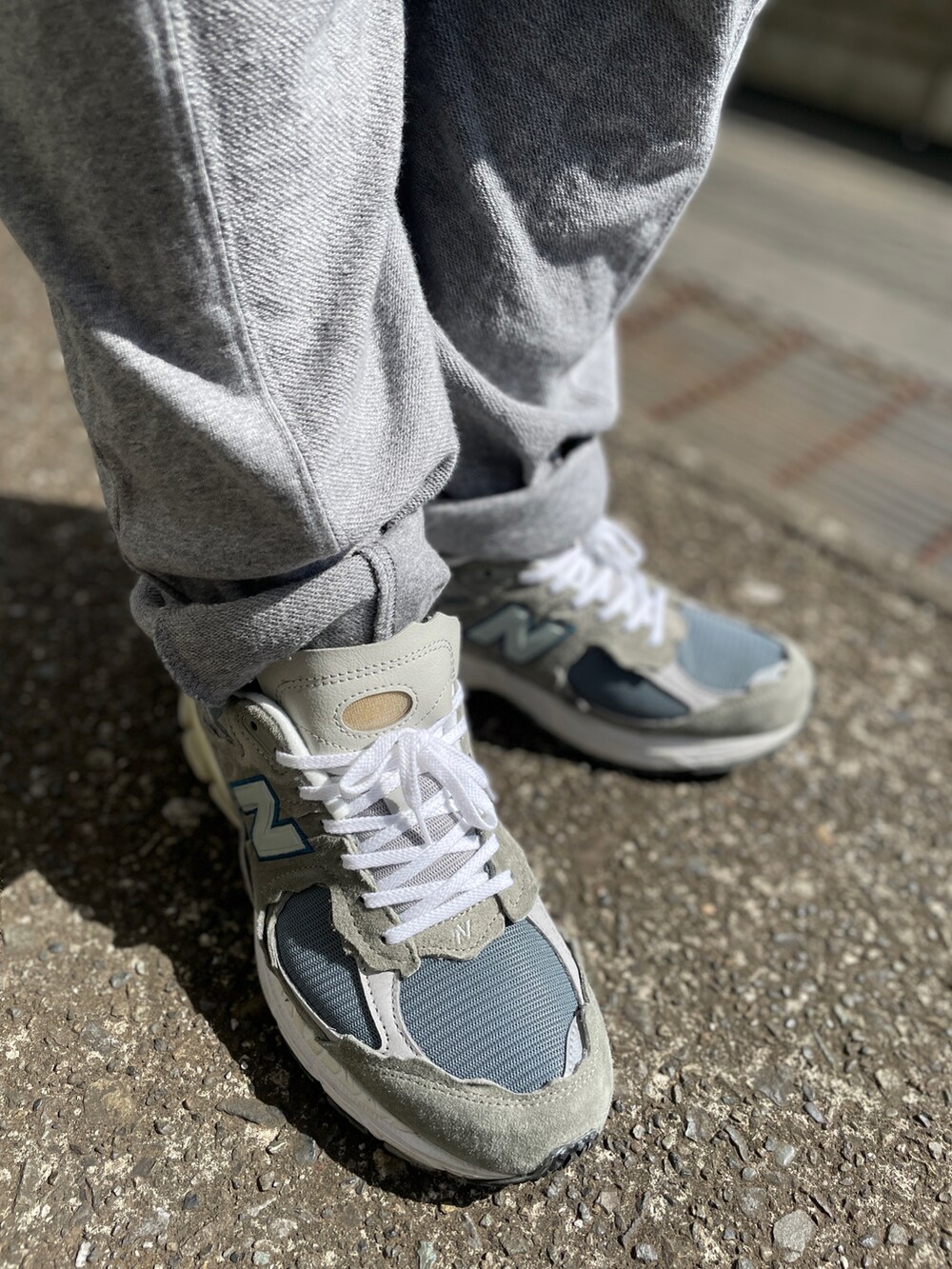 グレー系のスニーカー、グレー系のその他パンツ、ブルー系のTシャツ/カットソーを着用したメンズの春コーディネートの3枚目の写真