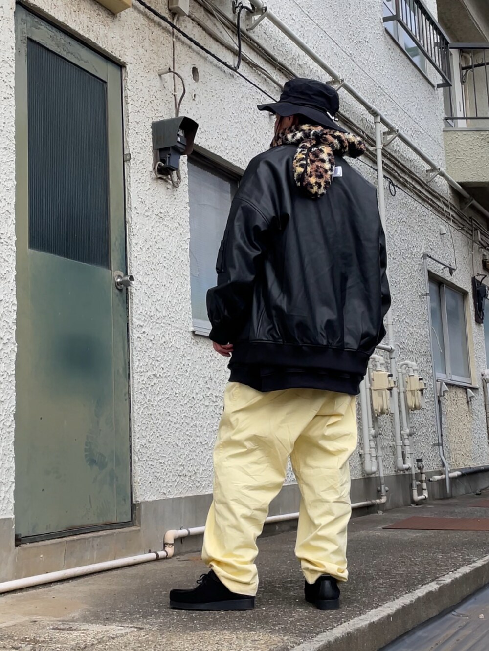 ブラック系のモカシン/デッキシューズ、イエロー系のその他パンツ、ブラック系のMA-1を着用したメンズの春コーディネートの2枚目の写真