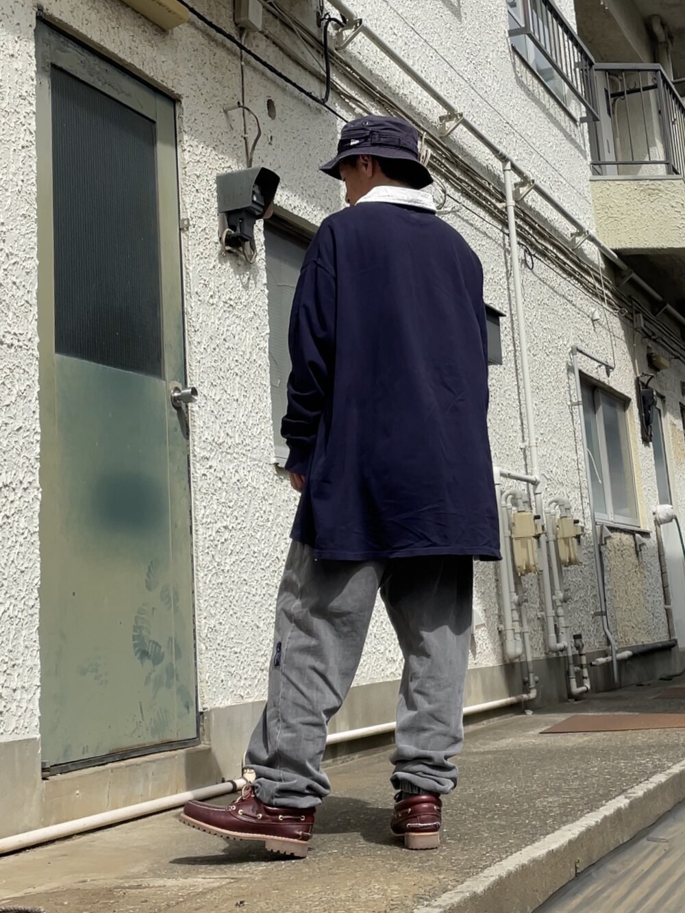 レッド系のモカシン/デッキシューズ、グレー系のスウェットパンツ、ブルー系のTシャツ/カットソーを着用したメンズの春コーディネートの2枚目の写真