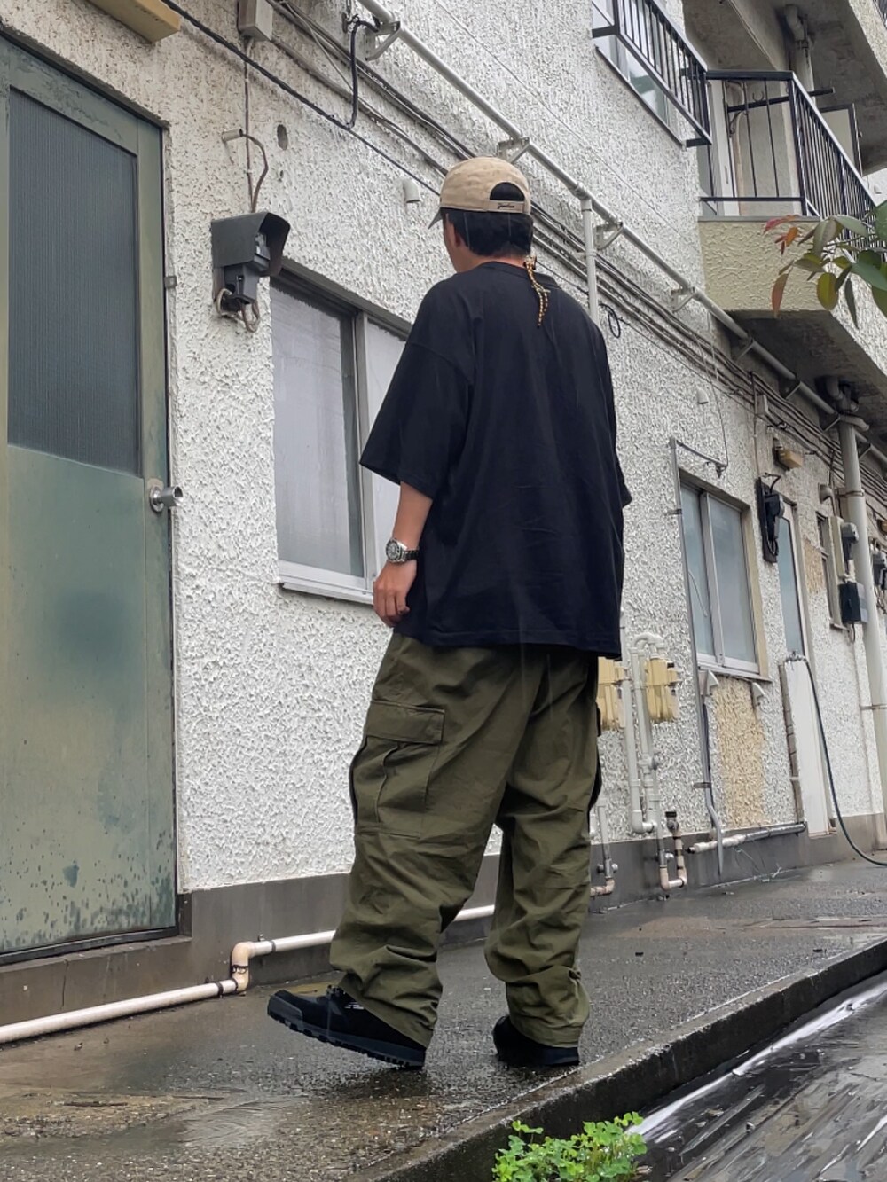 ブラック系のスニーカー、グリーン系のカーゴパンツ、ブラック系のTシャツ/カットソーを着用したメンズの夏コーディネートの2枚目の写真