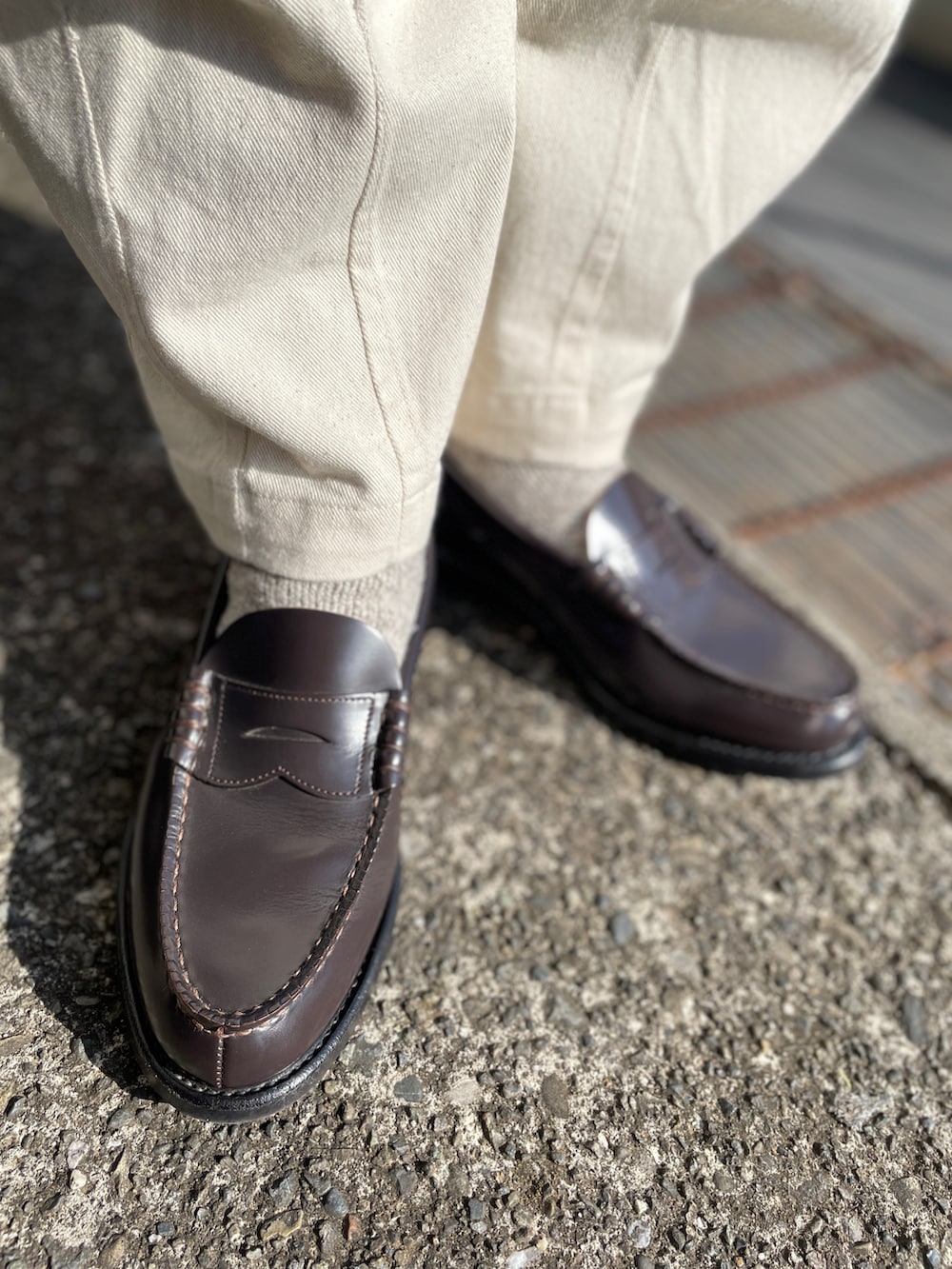 ブルー系のデニムジャケット、ブラウン系のローファー、ホワイト系のデニムパンツを着用したメンズの冬コーディネートの3枚目の写真