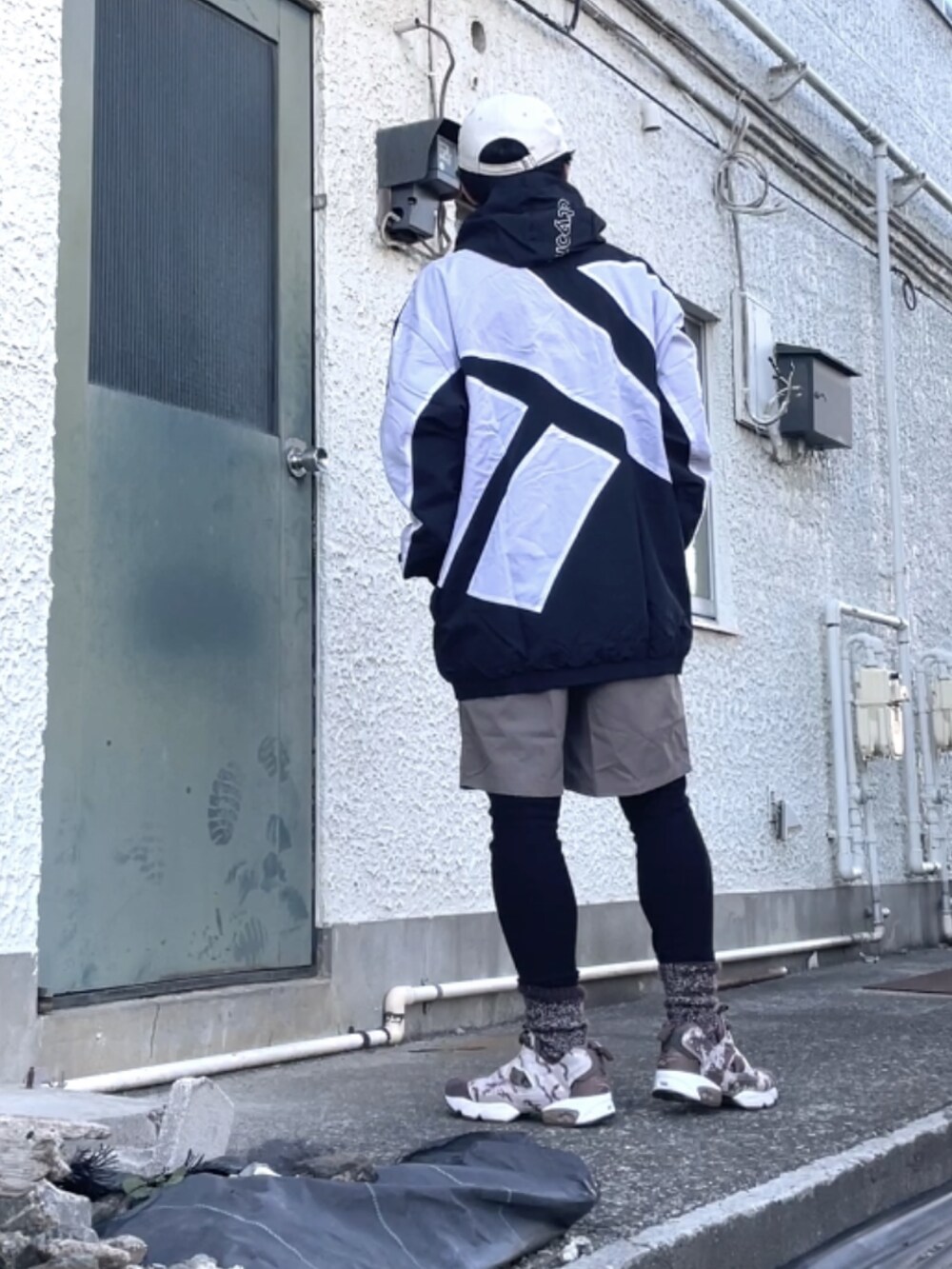 ブラウン系のスニーカー、ブラック系のマウンテンパーカー、ブラウン系のその他パンツを着用したメンズの冬コーディネートの3枚目の写真