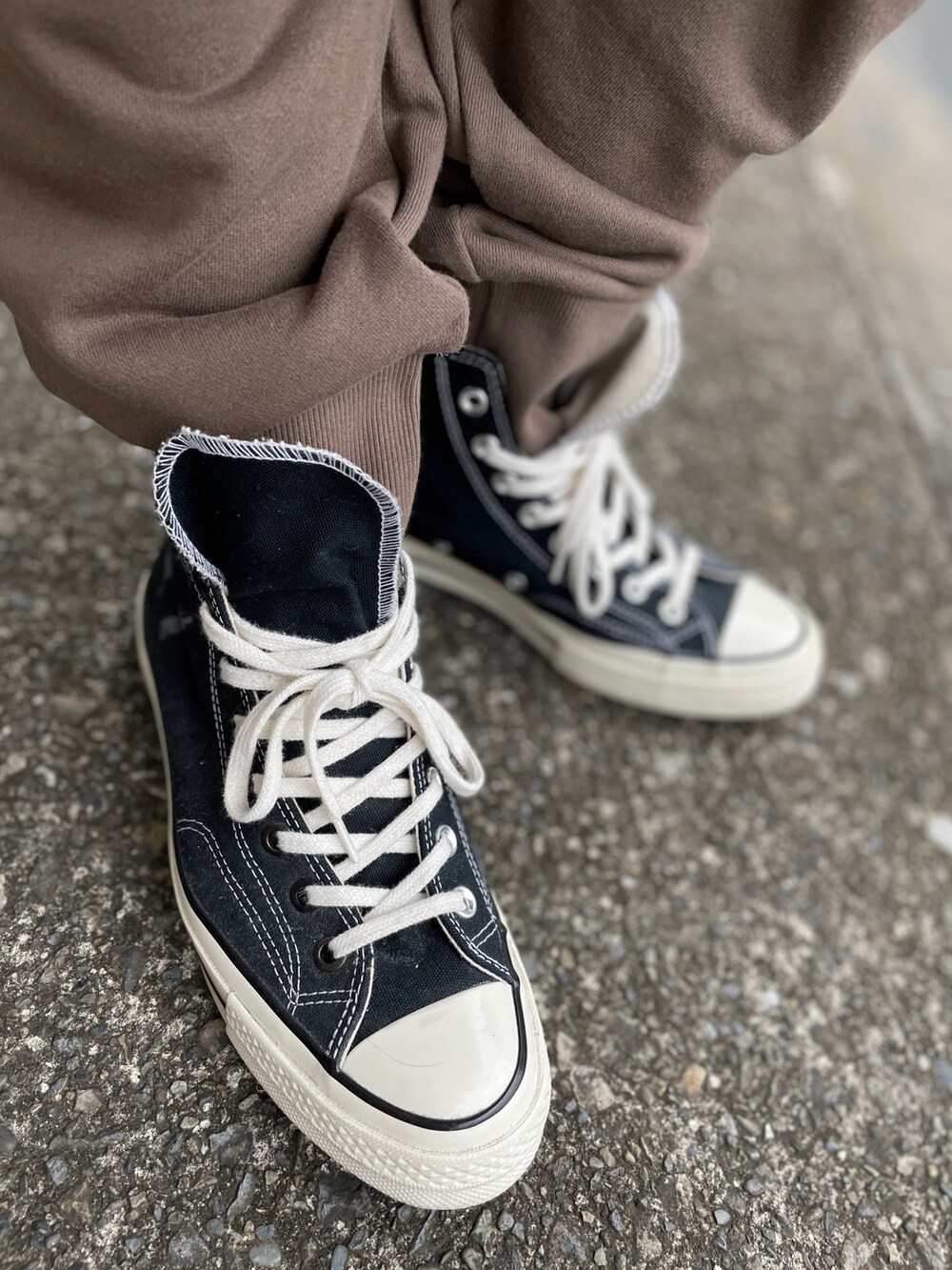 ブラック系のスニーカー、ブラウン系のパンツ、ホワイト系のTシャツ/カットソーを着用したメンズの秋コーディネートの3枚目の写真