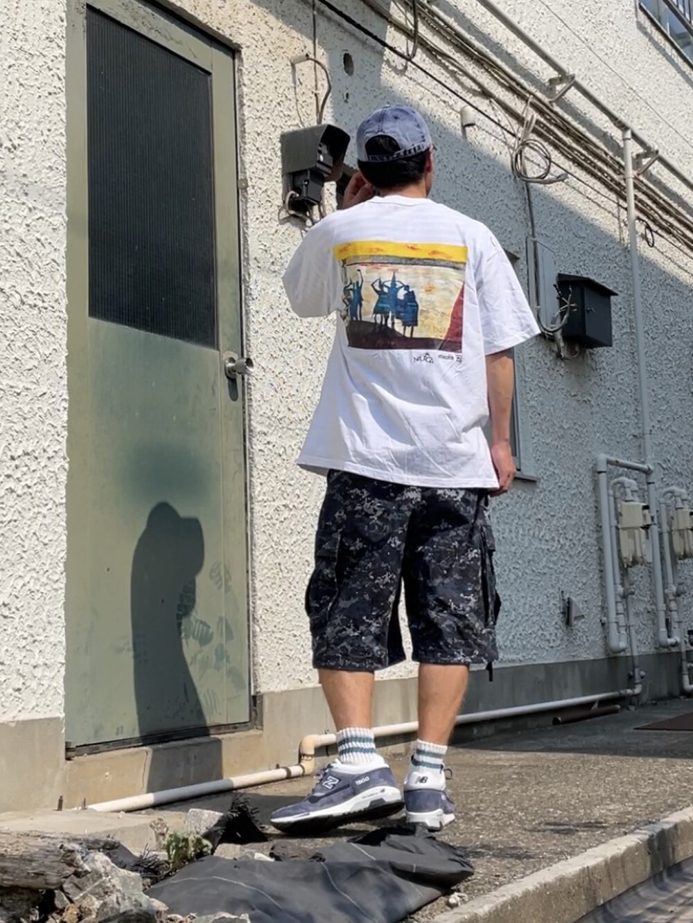 グレー系のスニーカー、ブルー系のカーゴパンツ、ホワイト系のTシャツ/カットソーを着用したメンズの秋コーディネートの2枚目の写真