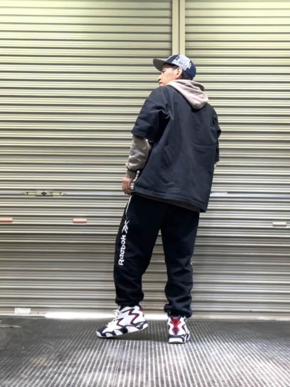 ホワイト系のスニーカー、ブラック系のスウェットパンツ、ブラック系のTシャツ/カットソーを着用したメンズの冬コーディネートの3枚目の写真