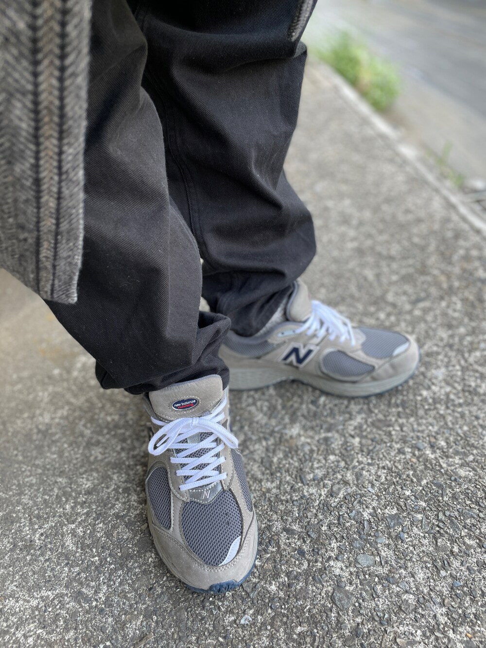 グレー系のスニーカー、ブラック系のその他パンツ、その他のTシャツ/カットソーを着用したメンズの春コーディネートの3枚目の写真