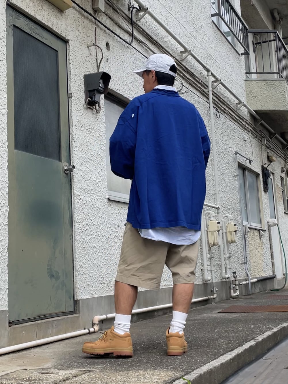 グリーン系のブーツ、ベージュ系のチノパンツ、ブルー系のTシャツ/カットソーを着用したメンズの秋コーディネートの2枚目の写真