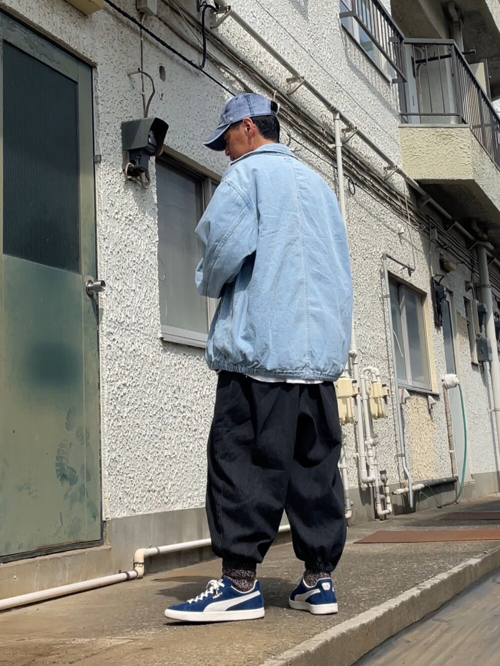 ブルー系のスニーカー、ブラック系のデニムパンツ、ブルー系のデニムジャケットを着用したメンズの春コーディネートの2枚目の写真