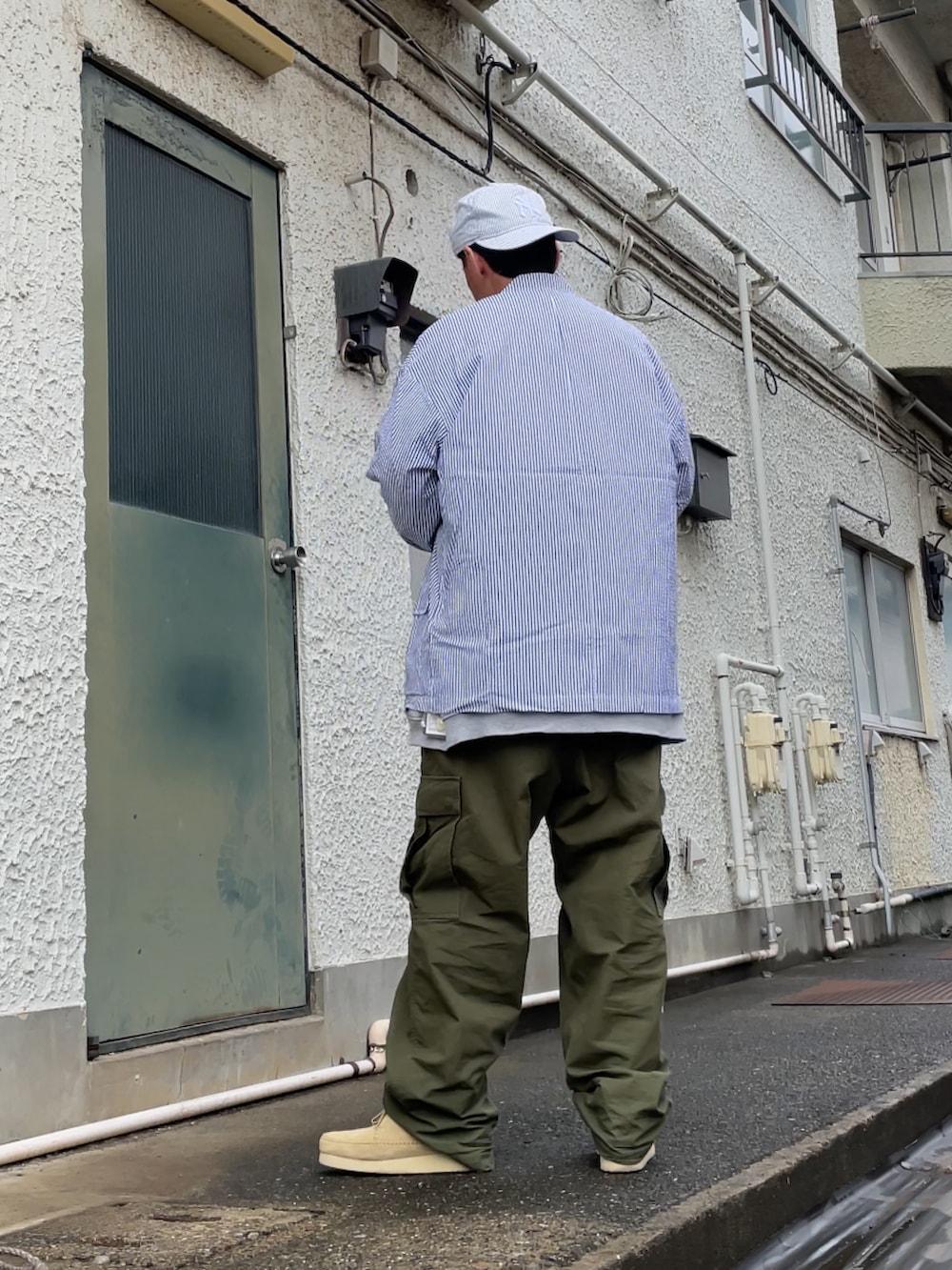 ベージュ系のモカシン/デッキシューズ、グリーン系のカーゴパンツ、グレー系のスウェットを着用したメンズの春コーディネートの2枚目の写真