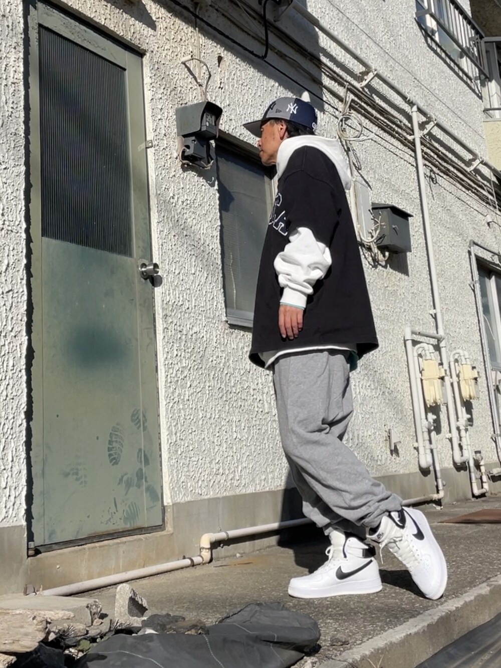 ホワイト系のスニーカー、グレー系のその他パンツ、ブラック系のTシャツ/カットソーを着用したメンズの冬コーディネートの2枚目の写真