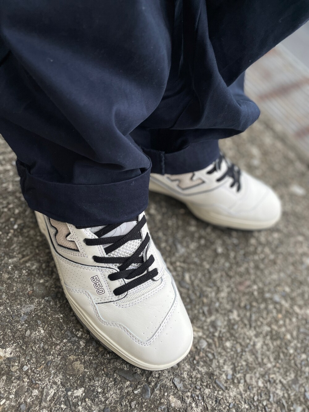 ホワイト系のスニーカー、ブルー系のチノパンツ、ブラック系のTシャツ/カットソーを着用したメンズの秋コーディネートの3枚目の写真