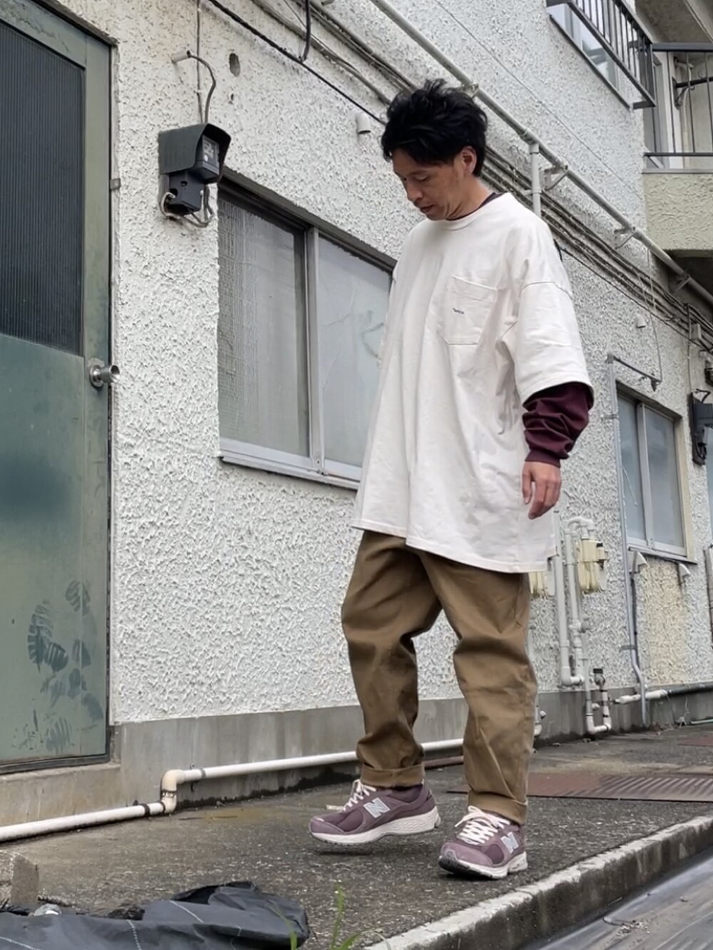 ブラウン系のスニーカー、ベージュ系のデニムパンツ、ベージュ系のTシャツ/カットソーを着用したメンズの春コーディネートの2枚目の写真