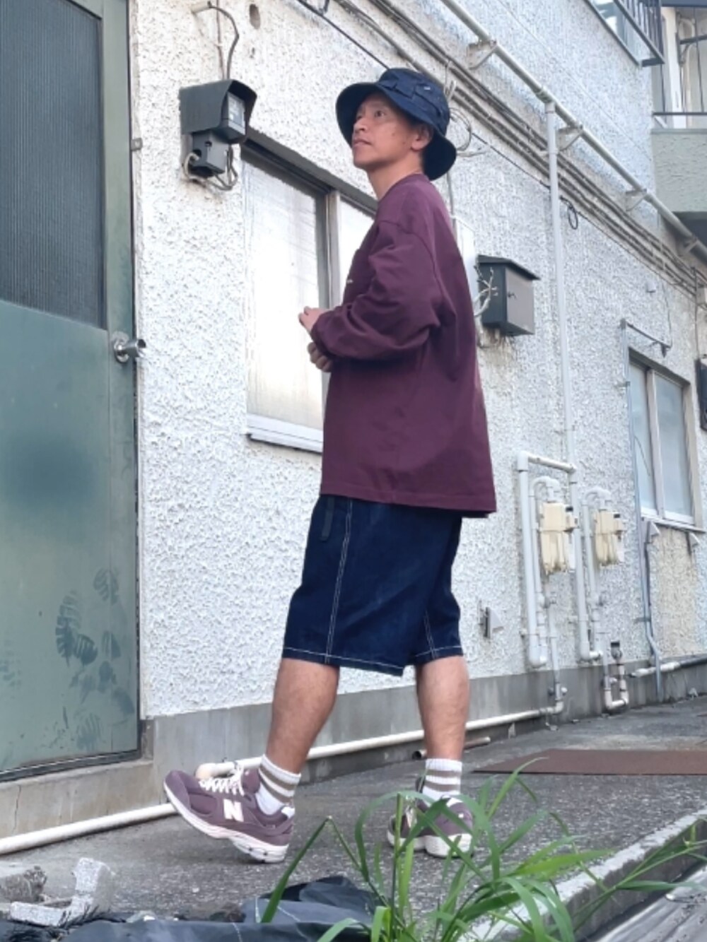ブラウン系のスニーカー、ブルー系のデニムパンツ、レッド系のスウェットを着用したメンズの春コーディネートの2枚目の写真