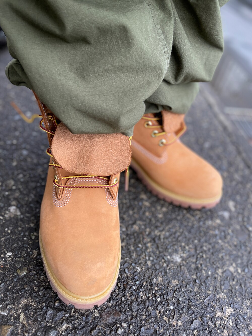 イエロー系のブーツ、グリーン系のカーゴパンツ、グレー系のスウェットを着用したメンズの春コーディネートの3枚目の写真