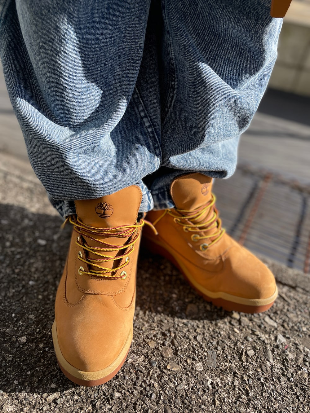 ホワイト系のスウェット、ブルー系のデニムパンツ、イエロー系のブーツを着用したメンズの冬コーディネートの3枚目の写真