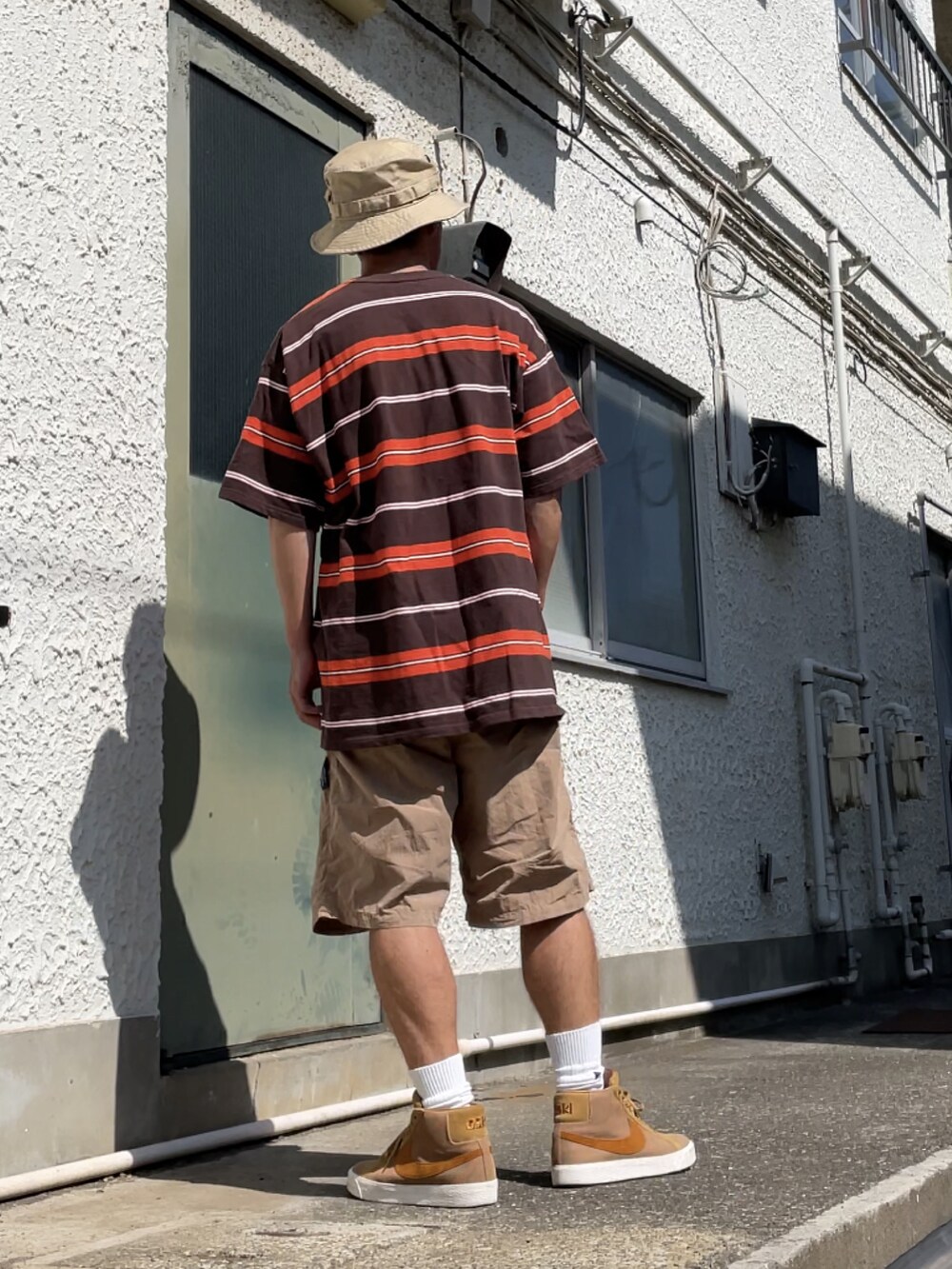 ブラウン系のスニーカー、ベージュ系のその他パンツ、ブラウン系のTシャツ/カットソーを着用したメンズの夏コーディネートの2枚目の写真