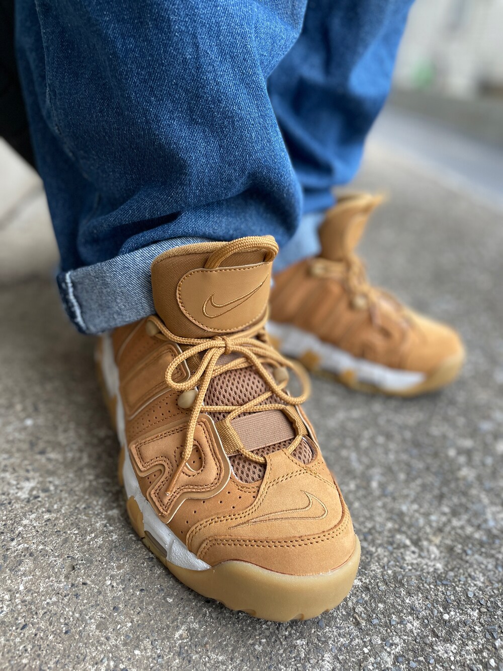 ブラウン系のスニーカー、ブルー系のデニムパンツ、グリーン系のTシャツ/カットソーを着用したメンズの秋コーディネートの3枚目の写真