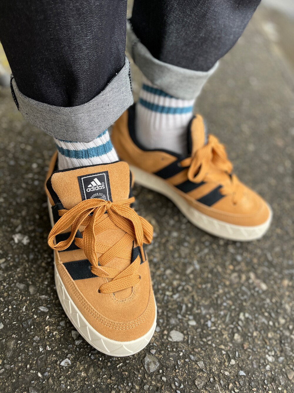 ブラウン系のスニーカー、ブラック系のデニムパンツ、ホワイト系のTシャツ/カットソーを着用したメンズの秋コーディネートの3枚目の写真