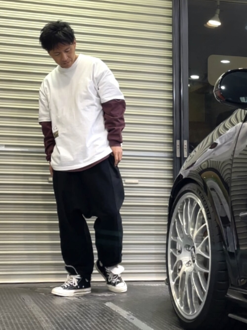 ブラック系のスニーカー、ブラック系のその他パンツ、ホワイト系のTシャツ/カットソーを着用したメンズの春コーディネートの2枚目の写真