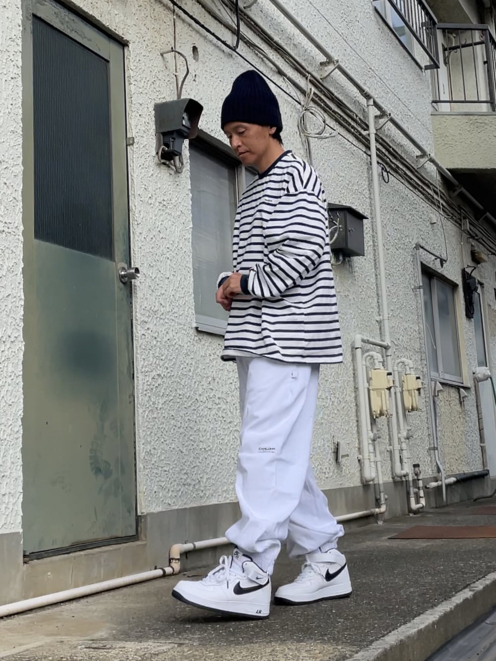 ホワイト系のスニーカー、ホワイト系のスウェットパンツ、ブルー系のTシャツ/カットソーを着用したメンズの秋コーディネートの2枚目の写真