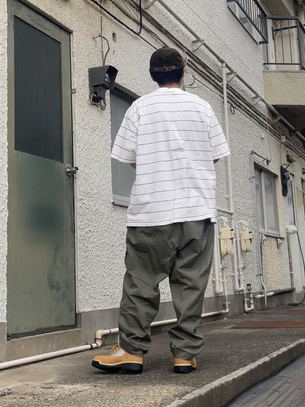 ベージュ系のブーツ、グリーン系のその他パンツ、ホワイト系のTシャツ/カットソーを着用したメンズの秋コーディネートの2枚目の写真