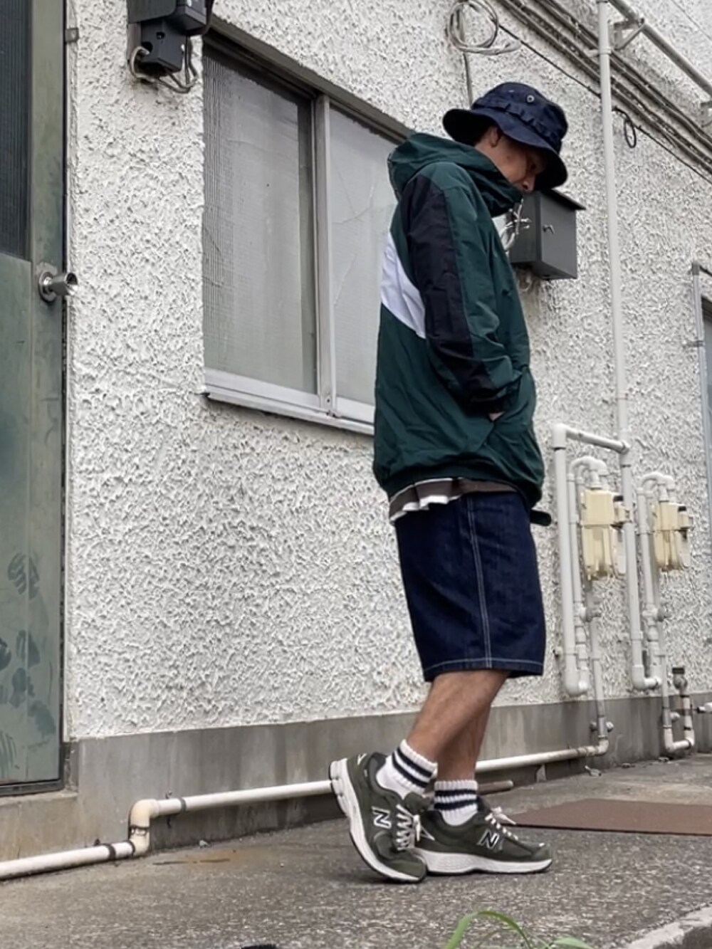 グリーン系のスニーカー、ブルー系のデニムパンツ、グリーン系のマウンテンパーカーを着用したメンズの春コーディネートの4枚目の写真