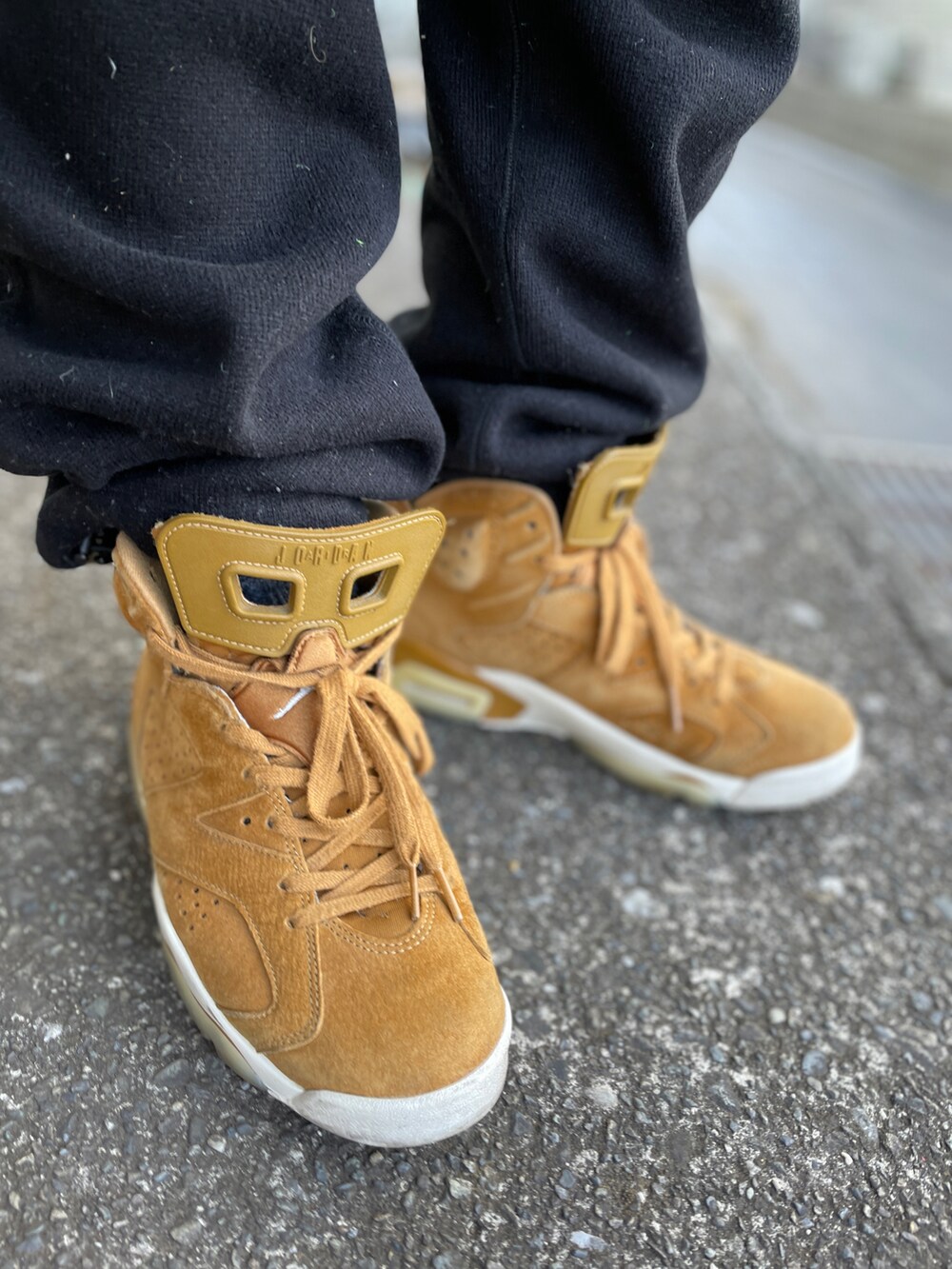 ブラウン系のスニーカー、ブラック系のスウェットパンツ、ホワイト系のスウェットを着用したメンズの冬コーディネートの3枚目の写真