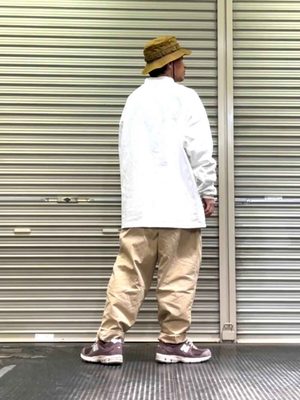 ブラウン系のスニーカー、ベージュ系のその他パンツ、ホワイト系のTシャツ/カットソーを着用したメンズの春コーディネートの3枚目の写真