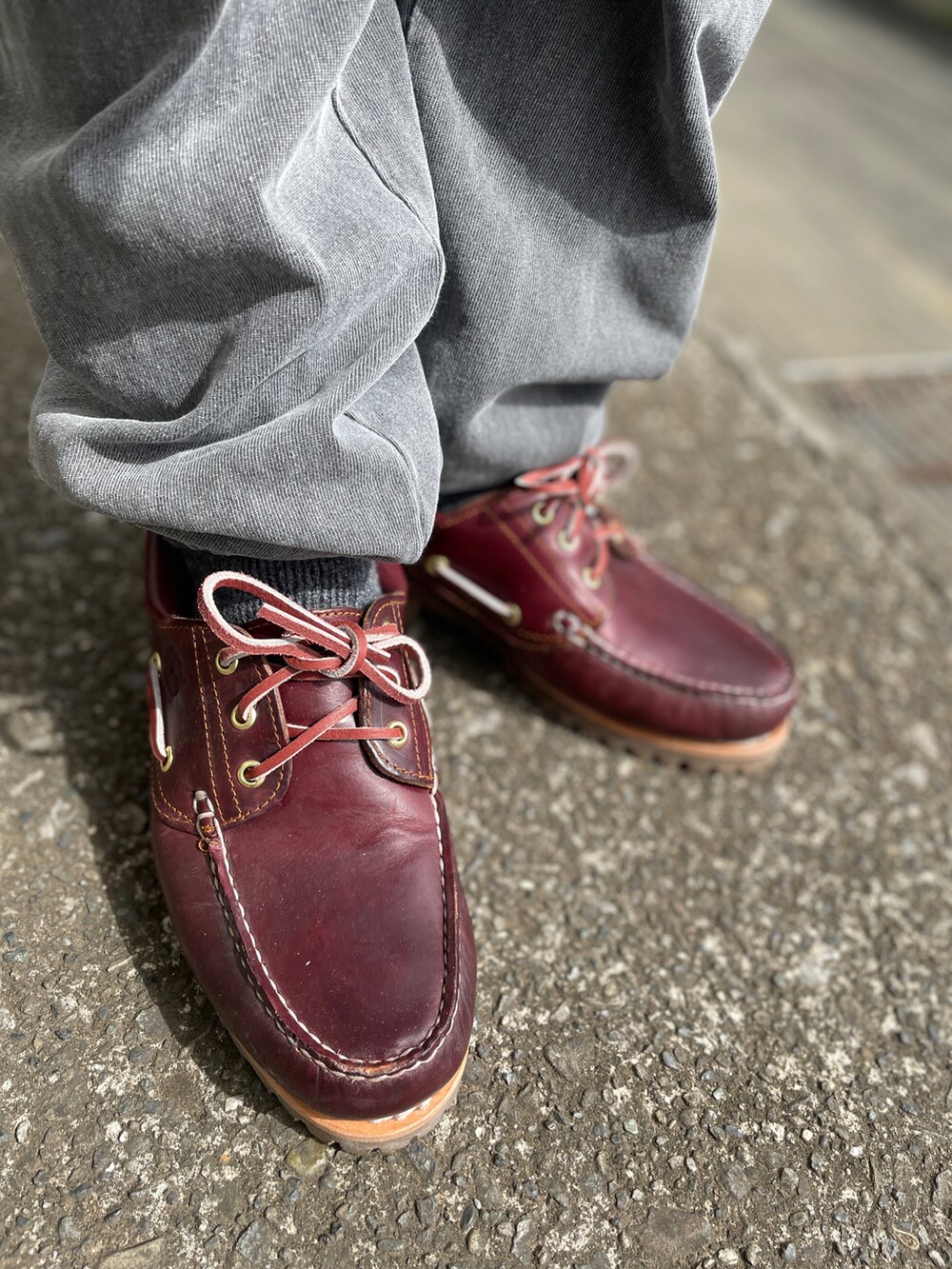 レッド系のモカシン/デッキシューズ、グレー系のスウェットパンツ、ブルー系のTシャツ/カットソーを着用したメンズの春コーディネートの3枚目の写真