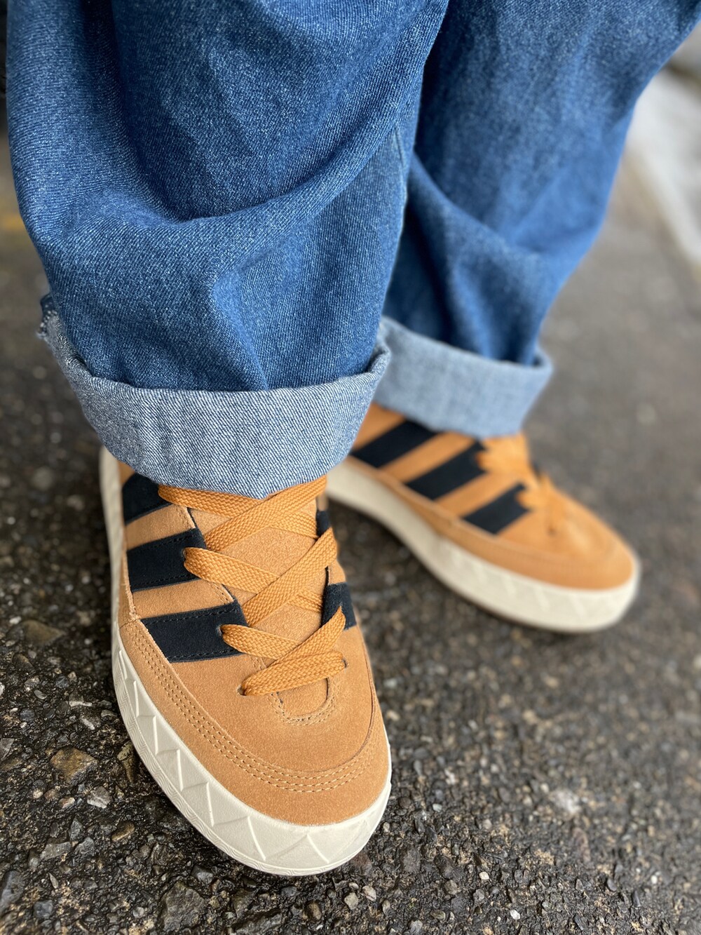 ブラウン系のスニーカー、ブルー系のデニムパンツ、グレー系のTシャツ/カットソーを着用したメンズの秋コーディネートの3枚目の写真