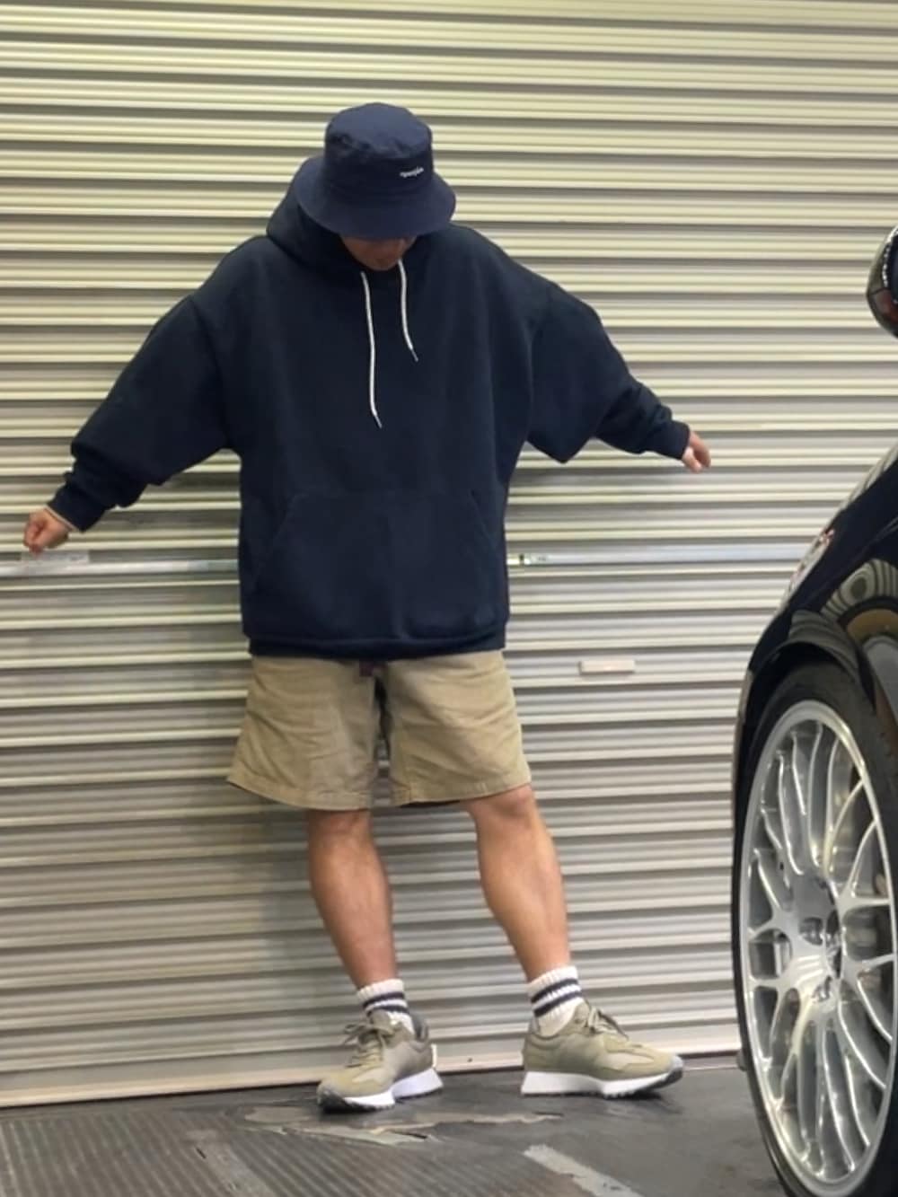 グリーン系のスニーカー、グリーン系のパンツ、ブルー系のパーカーを着用したメンズの春コーディネートの3枚目の写真