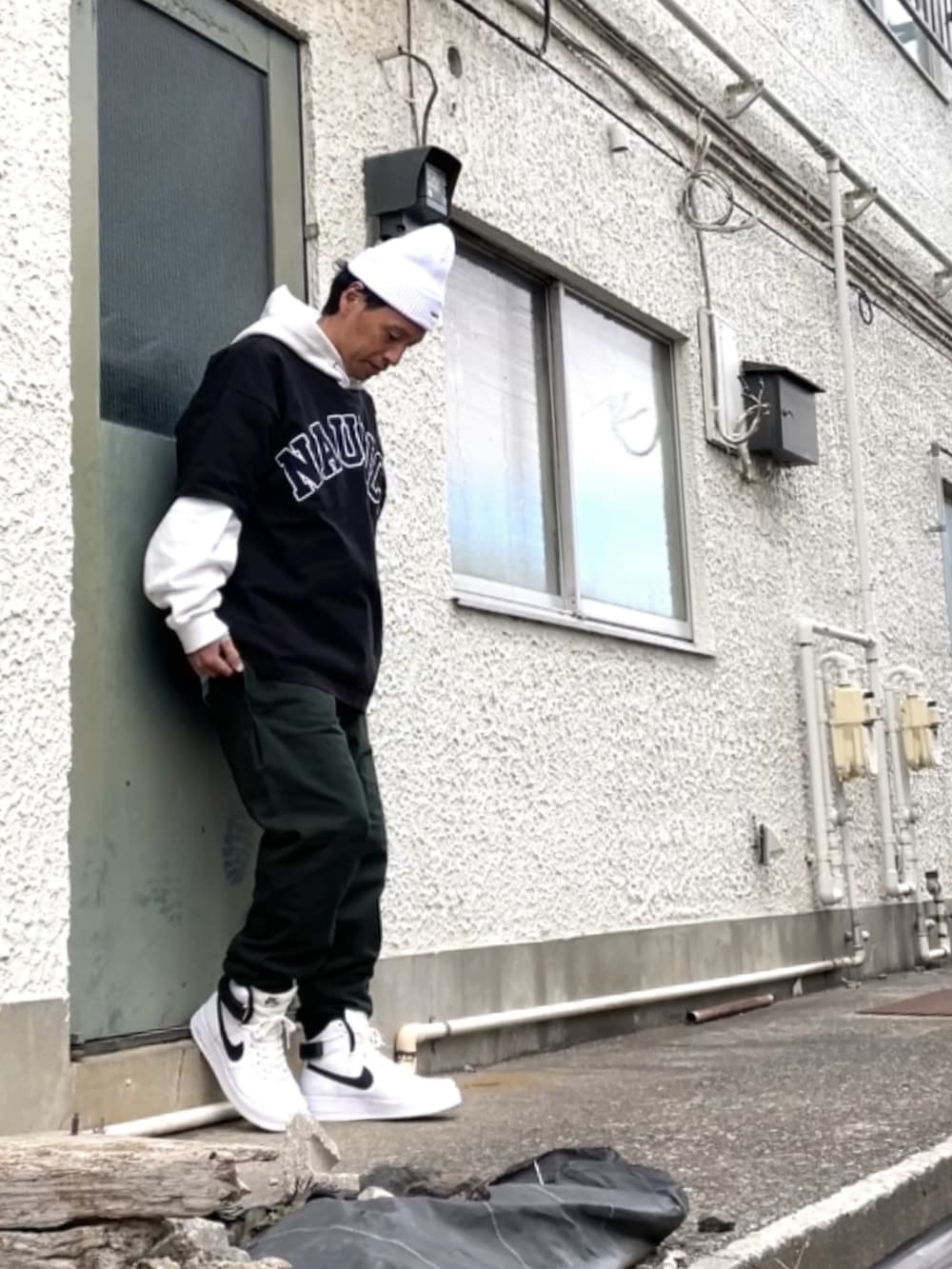 ホワイト系のスニーカー、グリーン系のその他パンツ、ブラック系のTシャツ/カットソーを着用したメンズの冬コーディネートの2枚目の写真