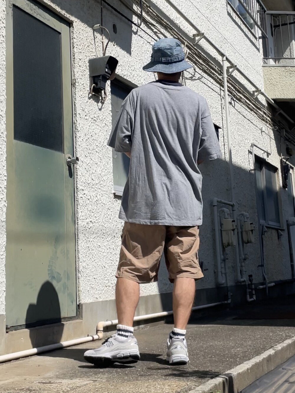 グレー系のスニーカー、ベージュ系のその他パンツ、グレー系のTシャツ/カットソーを着用したメンズの夏コーディネートの2枚目の写真