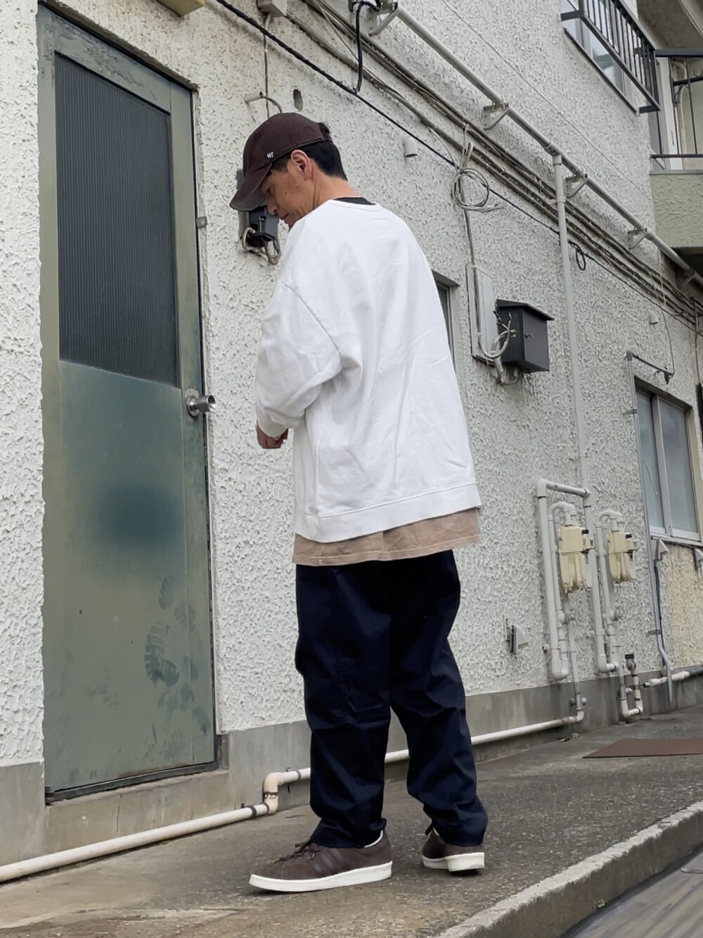 ブラウン系のスニーカー、ブルー系のその他パンツ、ホワイト系のスウェットを着用したメンズの春コーディネートの2枚目の写真