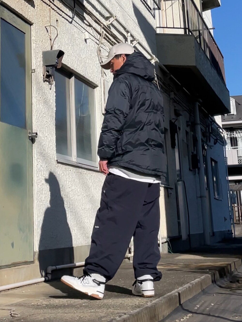 ホワイト系のスニーカー、ブルー系のその他パンツ、ブルー系のダウンジャケット/コートを着用したメンズの冬コーディネートの2枚目の写真