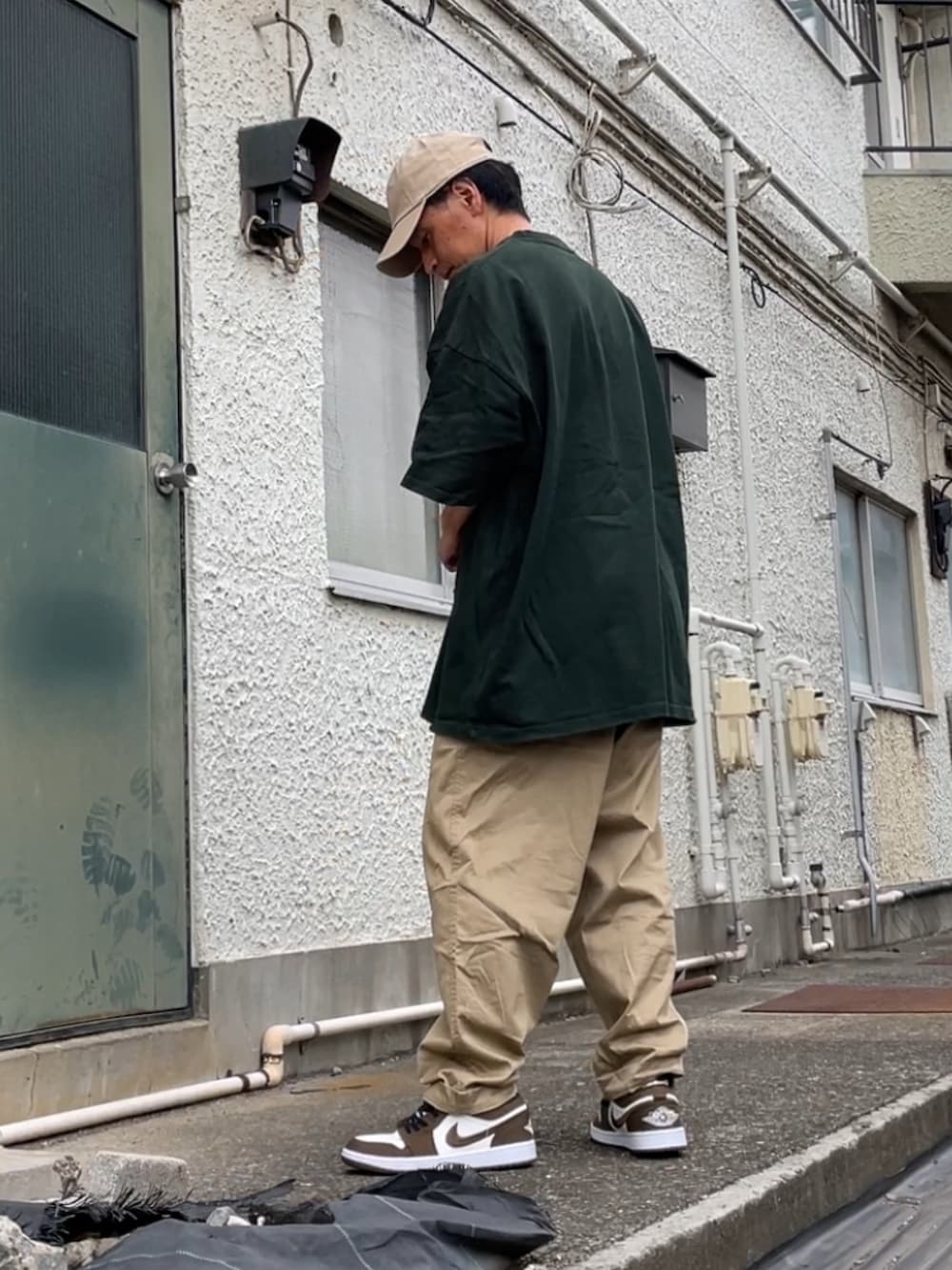 ブラウン系のスニーカー、ベージュ系のその他パンツ、グリーン系のTシャツ/カットソーを着用したメンズの秋コーディネートの2枚目の写真