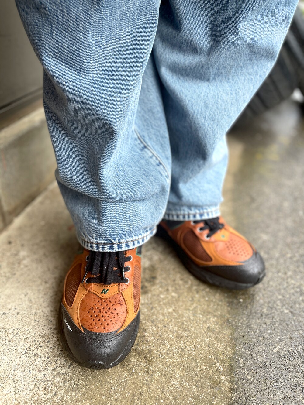 ブラウン系のスニーカー、ブルー系のデニムパンツ、グリーン系のポロシャツを着用したメンズの春コーディネートの3枚目の写真