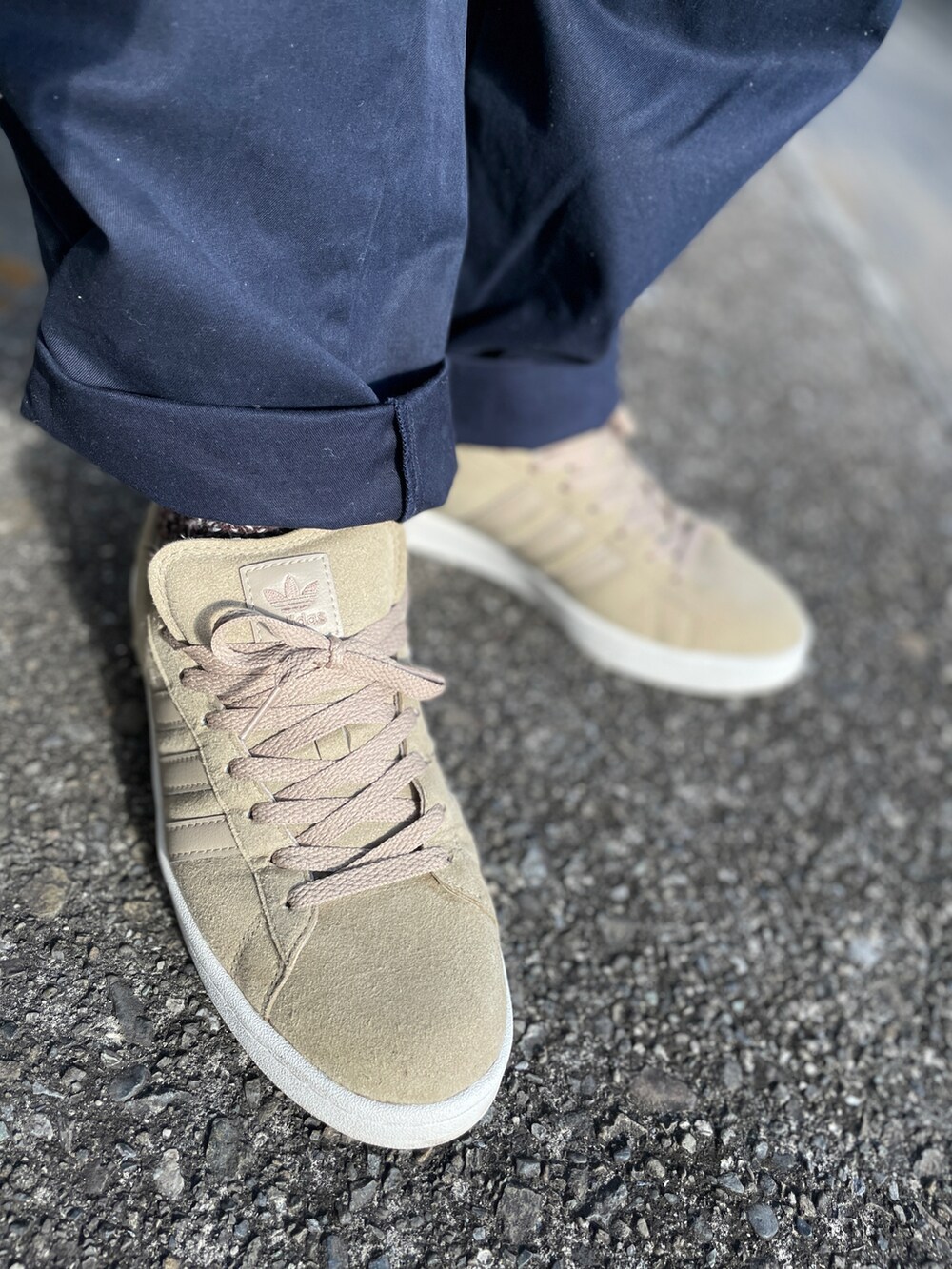 ベージュ系のスニーカー、ブルー系のチノパンツ、ブルー系のパーカーを着用したメンズの秋コーディネートの3枚目の写真