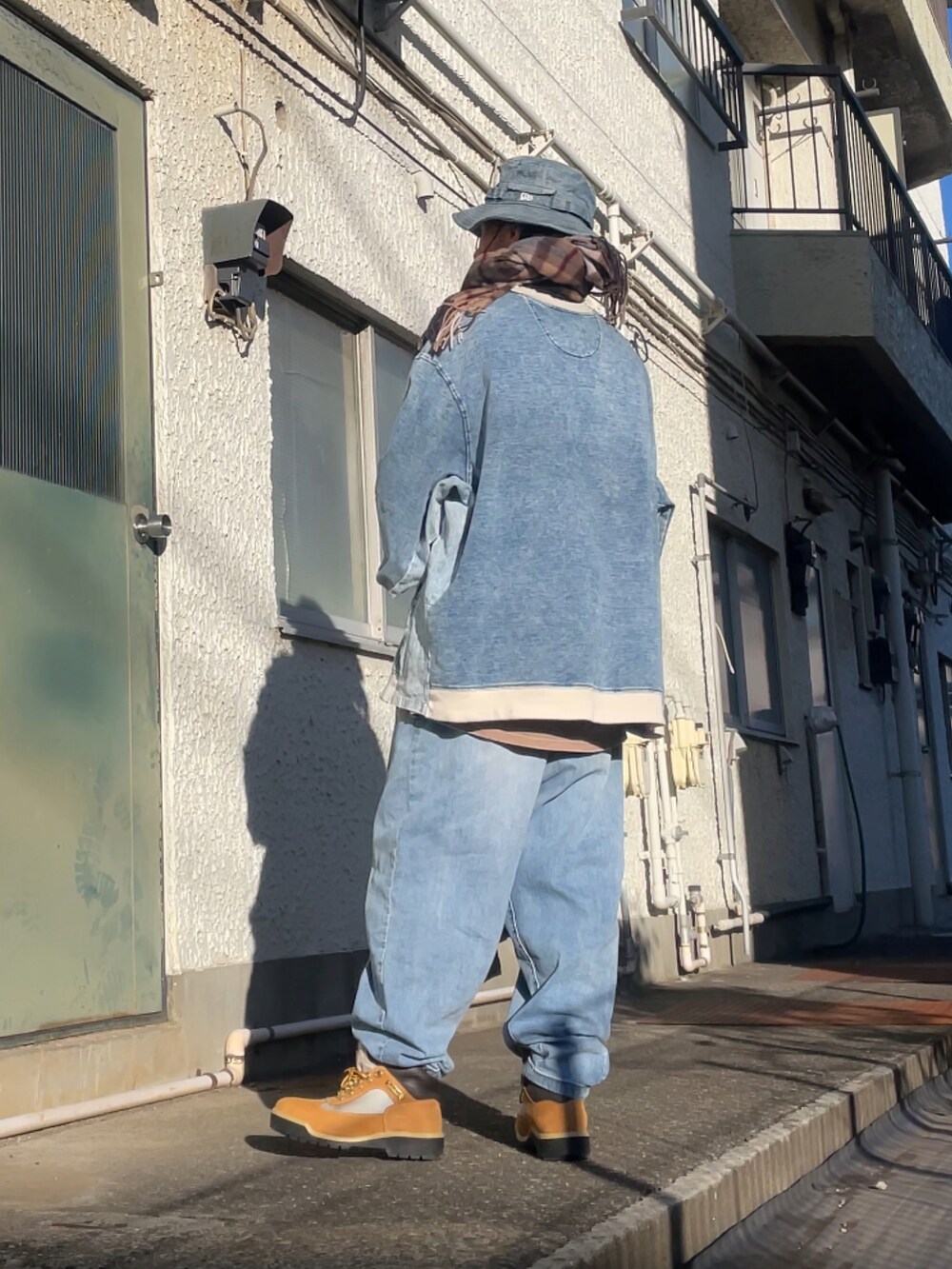 ベージュ系のブーツ、ブルー系のデニムパンツ、ブルー系のトップスを着用したメンズの冬コーディネートの2枚目の写真