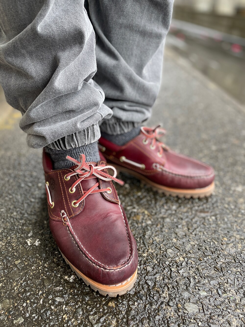 レッド系のモカシン/デッキシューズ、グレー系のスウェットパンツ、ブラック系のTシャツ/カットソーを着用したメンズの春コーディネートの3枚目の写真